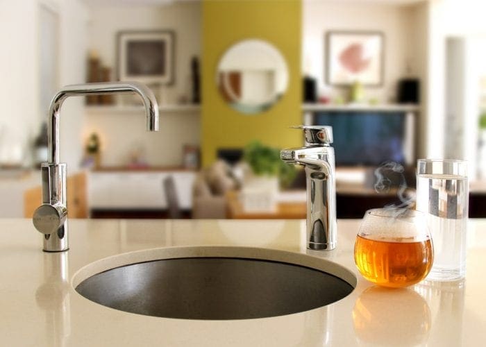 Billi Xl Chrome dispenser on kitchen sink with glass of water and mug of tea