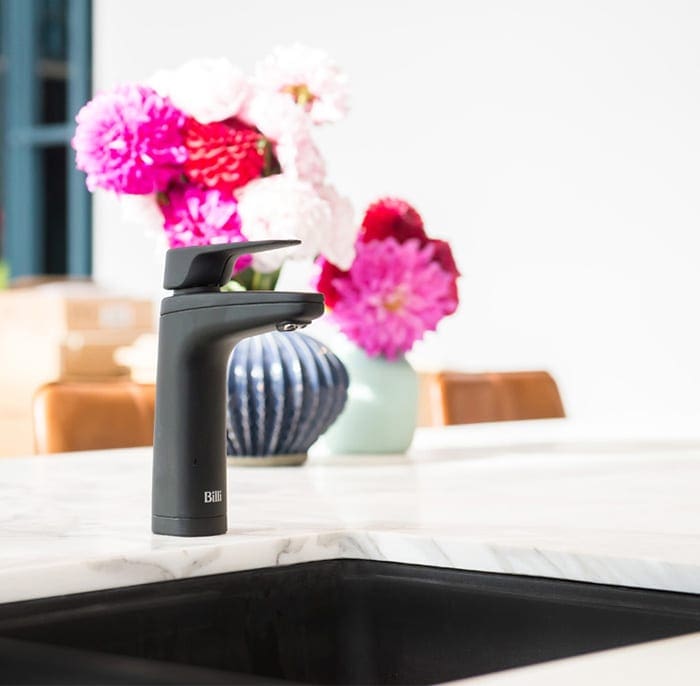 Billi XL Matte Black dispenser on kitchen bench with flowers