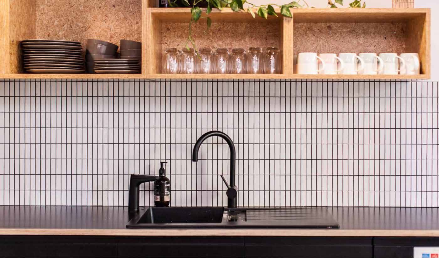 Matte Black XT dispenser on kitchen sink next to mixer tap