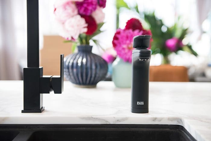 Matte Black XL dispenser on kitchen bench with flowers